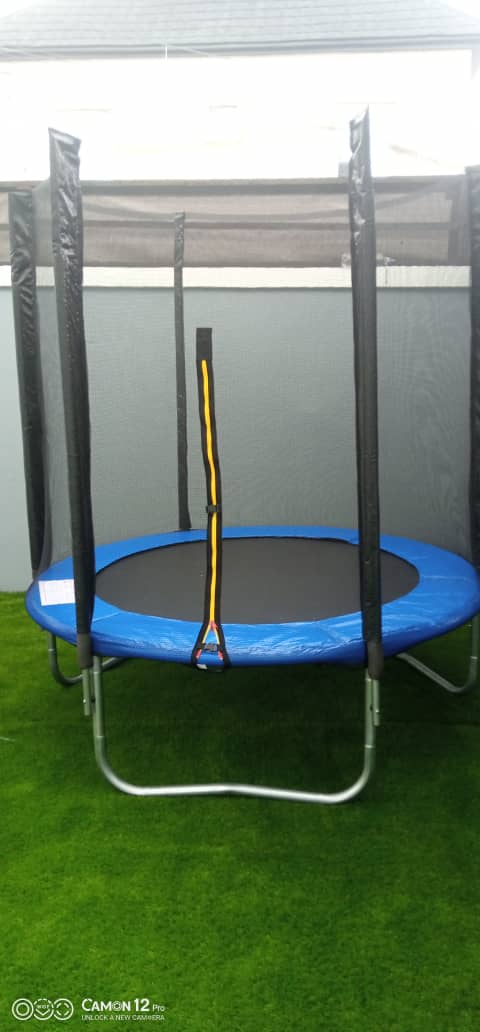 Enclosed safety net trampoline installed on artificial grass by Ere Ayo Mothercare Toys.
