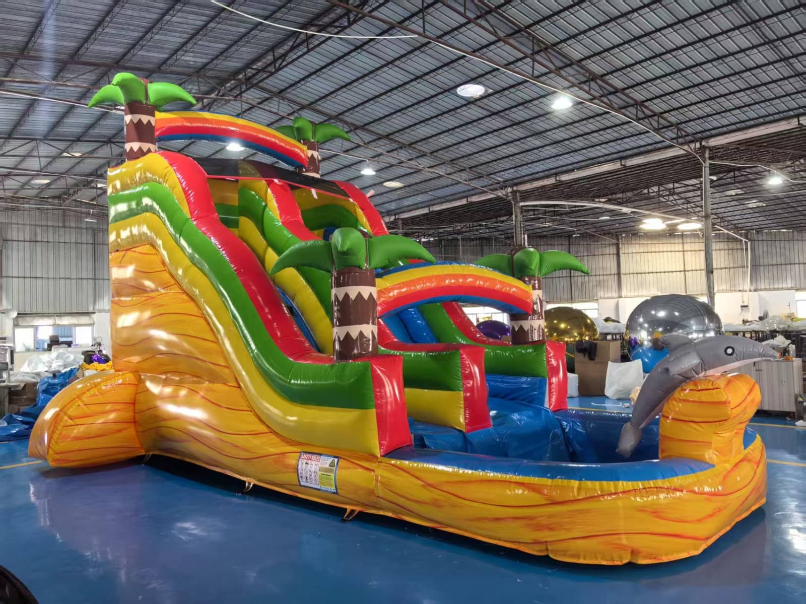 Tropical themed inflatable water slide with splash pool.