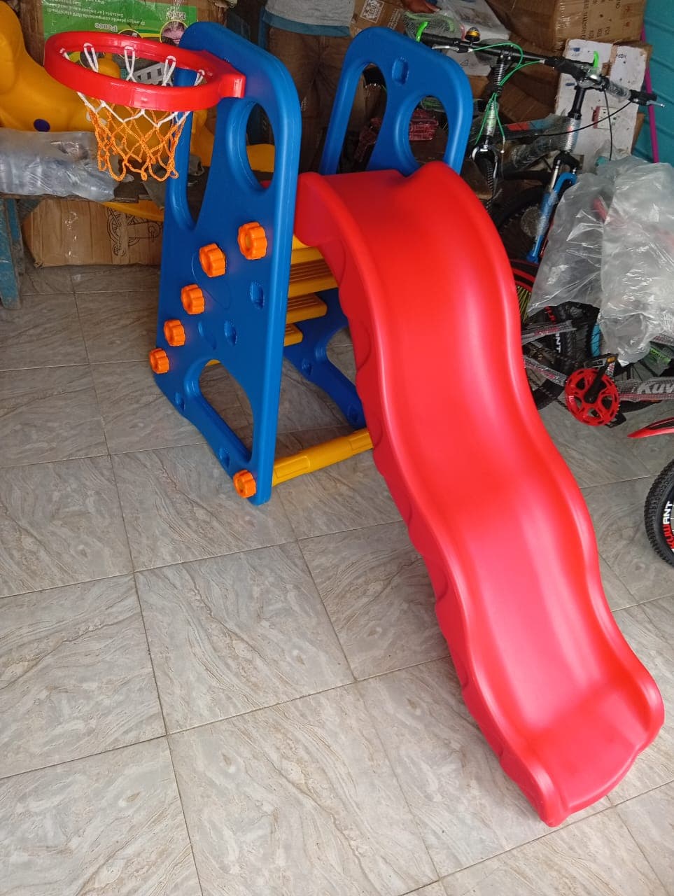 Toddler slide combined with a basketball hoop for indoor and outdoor play.
